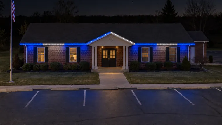 A township hall at night with permanent roofline lighting set to lions