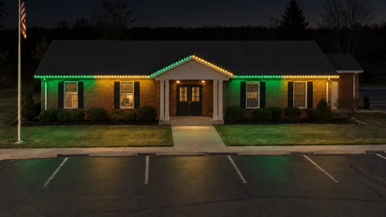 A township hall at night with permanent roofline lighting set to packers
