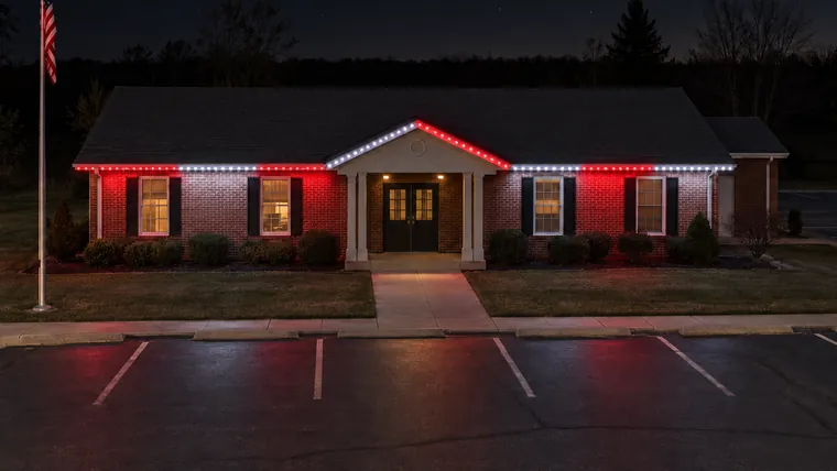 A township hall at night with permanent roofline lighting set to red wings
